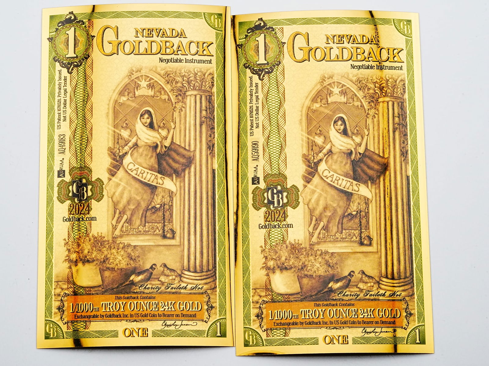 Lot of (2) 1 Nevada Goldbacks 1/1000th Ounce 24K Gold: Lot of (2) 1 Nevada Goldbacks 1/1000th Troy Ounce 24K Gold - A collectible lot of two Nevada Goldbacks, each containing 1/1000th troy ounce of 24K gold embedded within a beautifully detailed