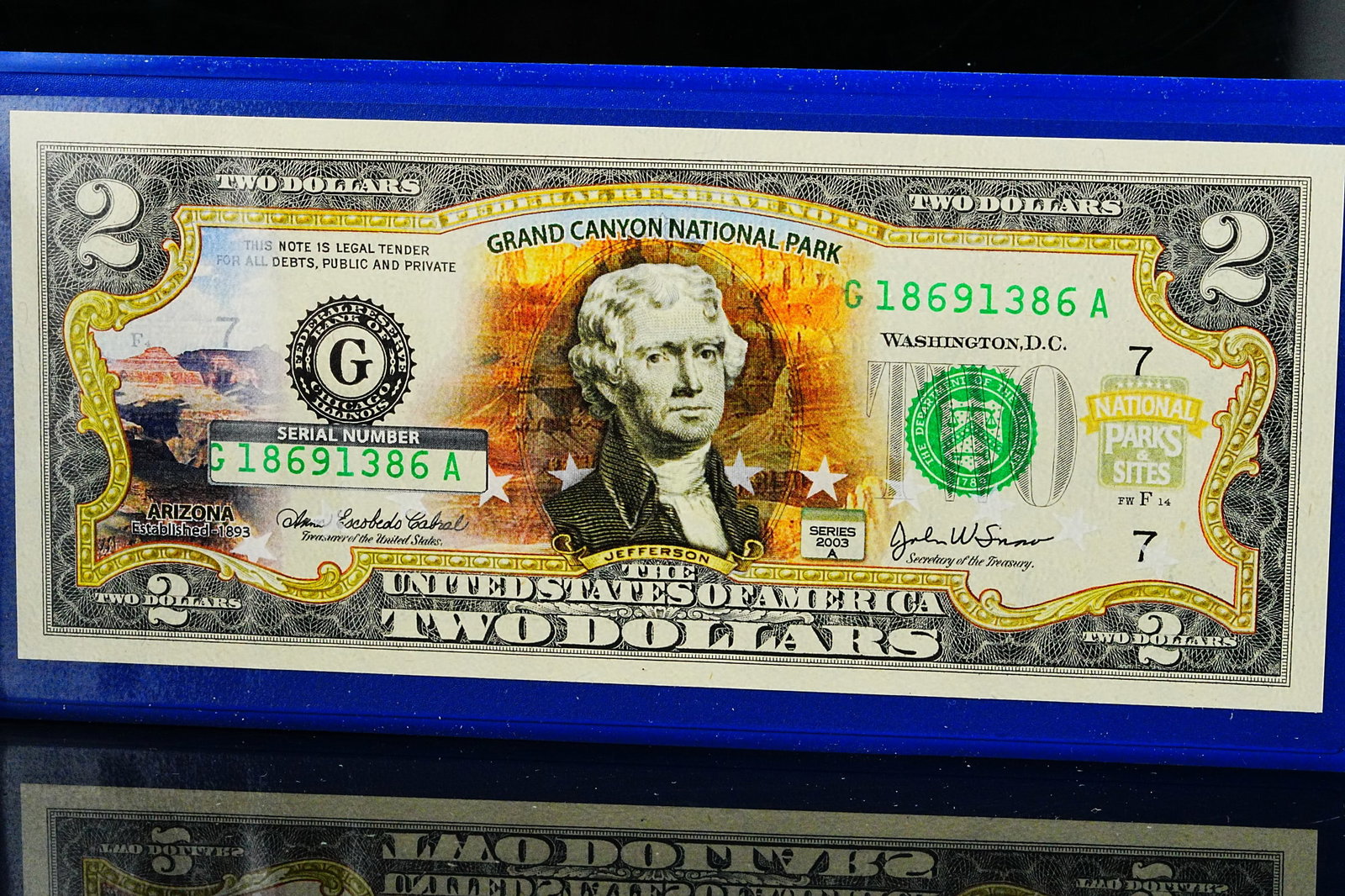 Grand Canyon National Park Colorized $2 Bill W/COA: Grand Canyon National Park Colorized $2 Bill W/Original Case and COA - A striking collectible currency piece featuring an authentic United States $2 bill enhanced with a vibrant Grand Canyon National