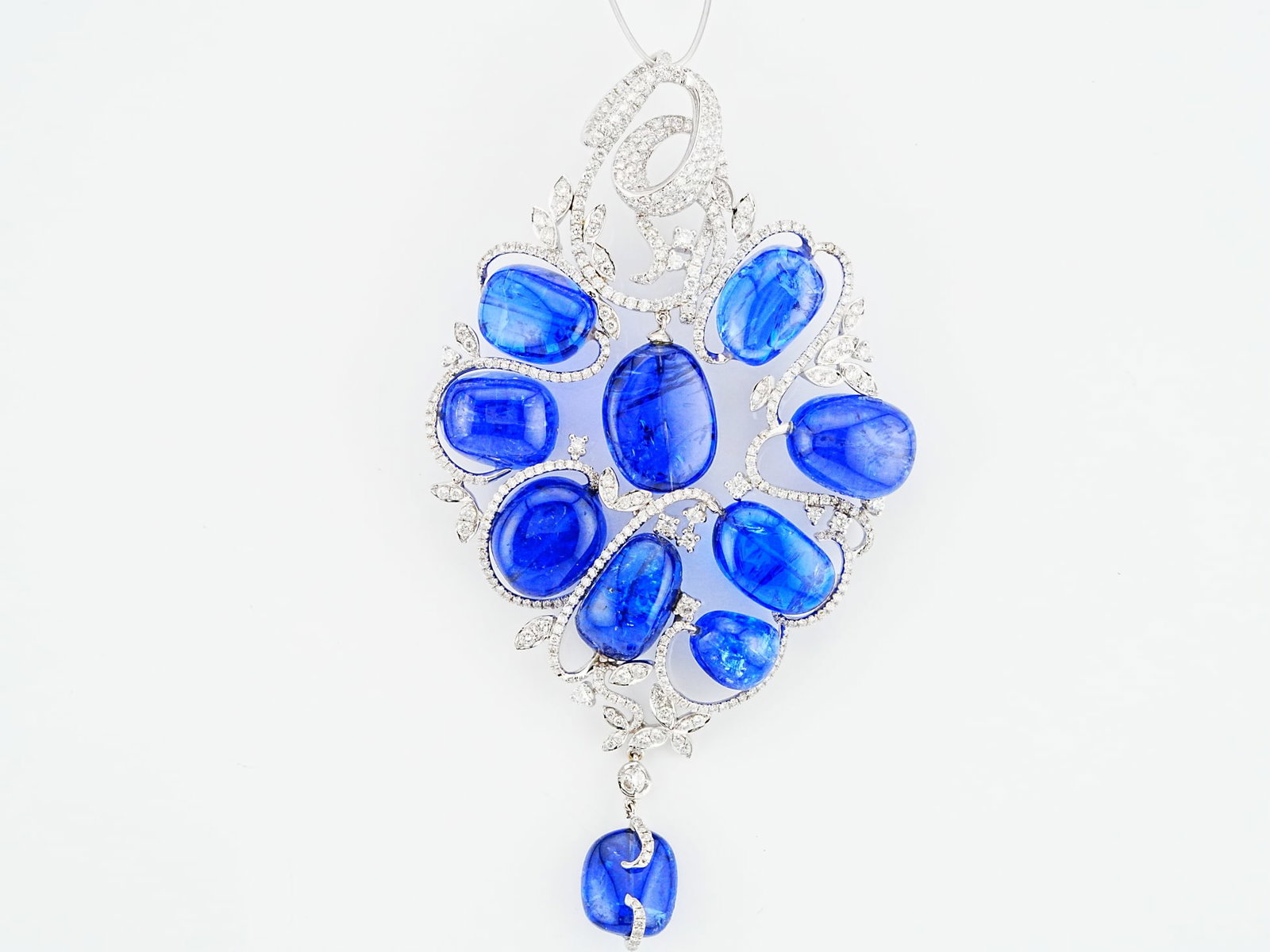 155.85ctw Tanzanite, 5.40ctw Diamond, 18K 4.25" Pendant: 155.85ctw Tanzanite, 5.40ctw VS1-SI1/G-H Diamond and 18K White Gold 4.25" Statement Pendant - THIS ITEM WILL COME WITH A $42,000 INSURANCE VALUATION REPORT. A bold and sculptural expression of high je
