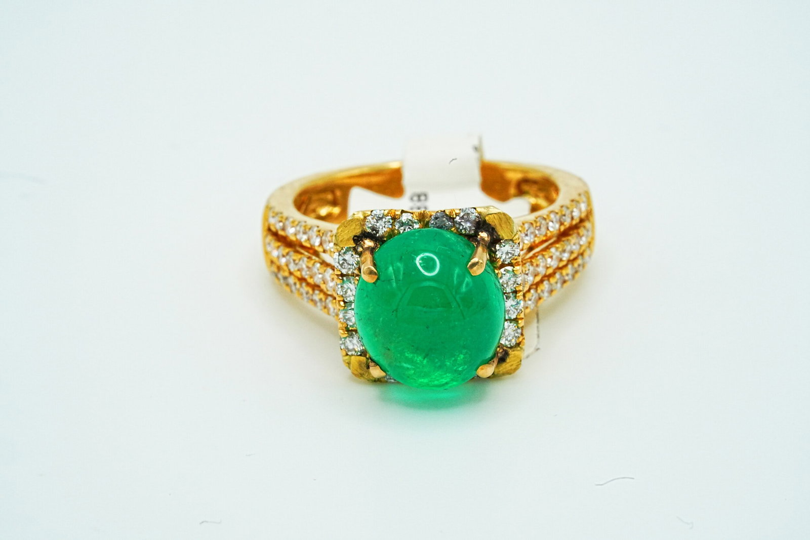 4.88ct Colombian Emerald, 1.29ctw Diamond and 18K Ring: 4.88ct Cabochon Colombian Emerald, 1.29ctw Diamond and 18K Yellow Gold Ring - THIS ITEM WILL COME WITH A $47,000 INSURANCE VALUATION REPORT. This 18k yellow gold ring features a 4.88ct cabochon Colomb
