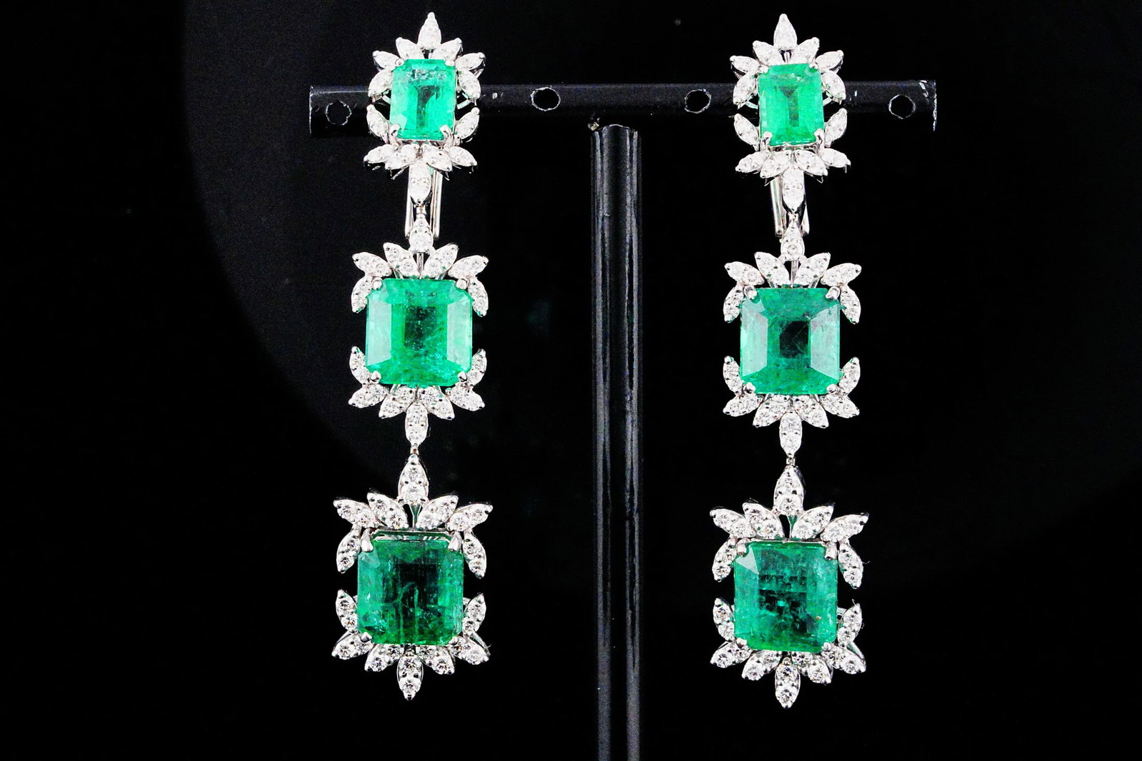 25.40ctw Emerald, 3.00ctw Diamond and 18K Earrings: 25.40ctw Emerald, 3.00ctw SI1-SI2/G-H Diamond and 18K White Gold 2.60" Dangle Earrings - THIS ITEM WILL COME WITH A $64,000 INSURANCE VALUATION REPORT. These breathtaking dangle earrings showcase appr