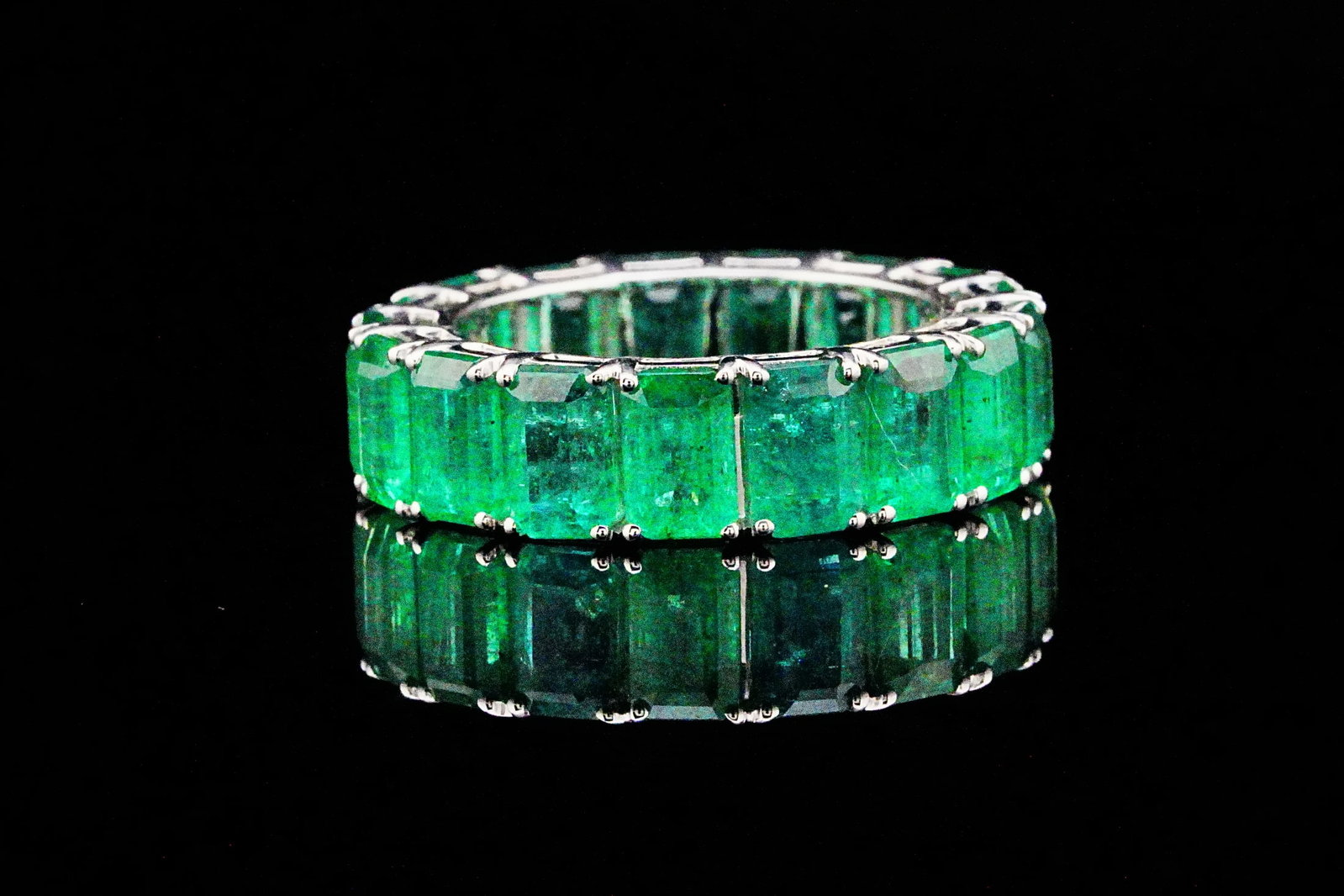 10.20ctw Emerald and 18K White Gold Eternity Band: 10.20ctw Emerald and 18K White Gold 6.3mm Wide Eternity Band - THIS ITEM WILL COME WITH A $12,500 INSURANCE VALUATION REPORT. A striking expression of timeless elegance and exceptional gemstone beauty