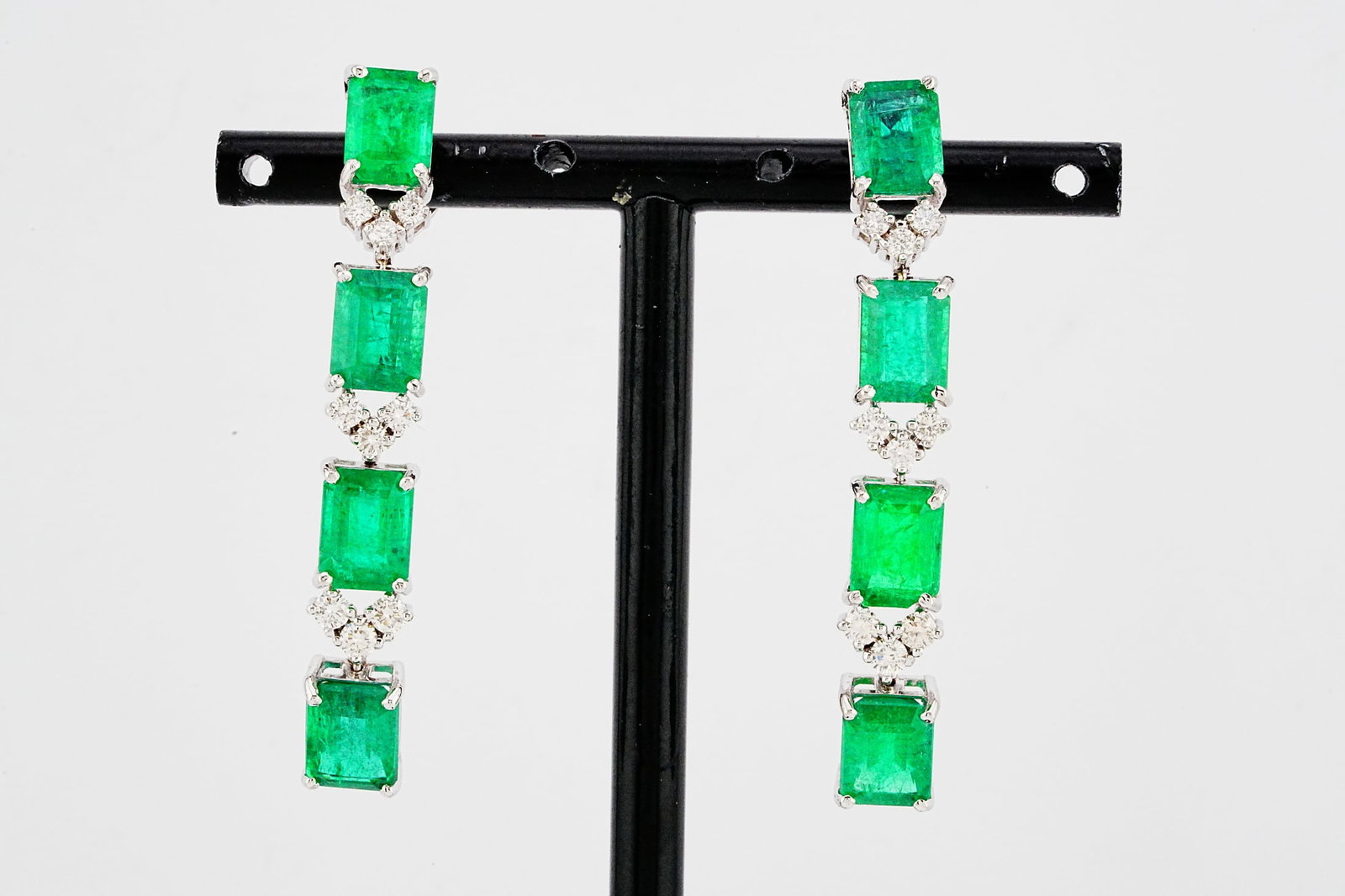 12.80ctw Emerald, 0.80ctw Diamond and 18K 2" Earrings: 12.80ctw Emerald, 0.80ctw VS1-SI1/G-H Diamond and 18K White Gold 2" Dangle Earrings - THIS ITEM WILL COME WITH A $27,000 INSURANCE VALUATION REPORT. Exceptionally elegant and dramatic in design, these