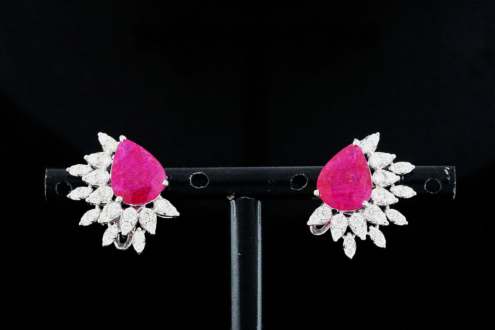 5.20ctw Ruby, 1.00ctw Diamond and 18K Earrings: 5.20ctw Ruby, 1.00ctw SI1-SI2/G-H Diamond and 18K White Gold 0.75" Cluster Earrings - THIS ITEM WILL COME WITH A $9,500 INSURANCE VALUATION REPORT. These elegant cluster earrings showcase approximatel