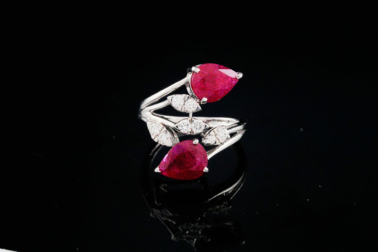 3.50ctw Ruby, 0.35ctw Diamond and 18K Bypass Ring: 3.50ctw Ruby, 0.35ctw Diamond and 18K White Gold Bypass Ring - THIS ITEM WILL COME WITH A $7,500 INSURANCE VALUATION REPORT. This elegant bypass style ring features two pear cut rubies totaling approx