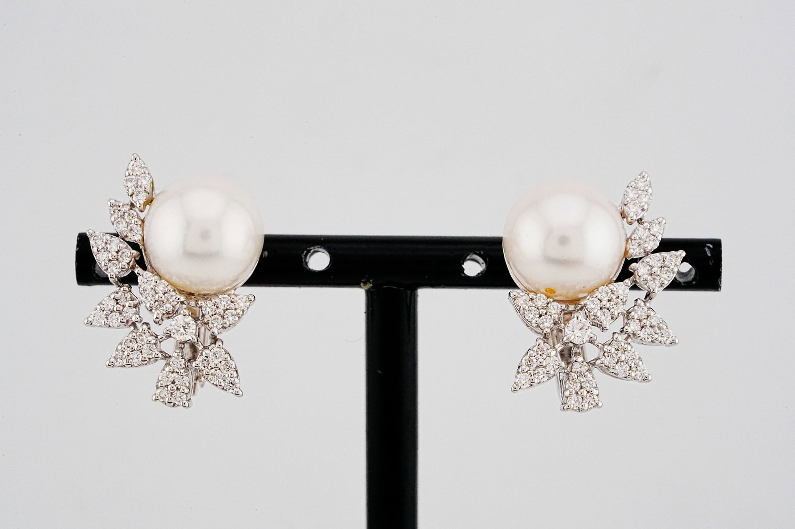 11mm Pearl, 1.05ctw Diamond and 18K 1" Earrings: 11mm Pearl, 1.05ctw SI1-SI2/G-H Diamond and 18K White Gold 1" Earrings - THIS ITEM WILL COME WITH A $10,000 INSURANCE VALUATION REPORT. Elegantly crafted in polished 18K white gold, these refined earr