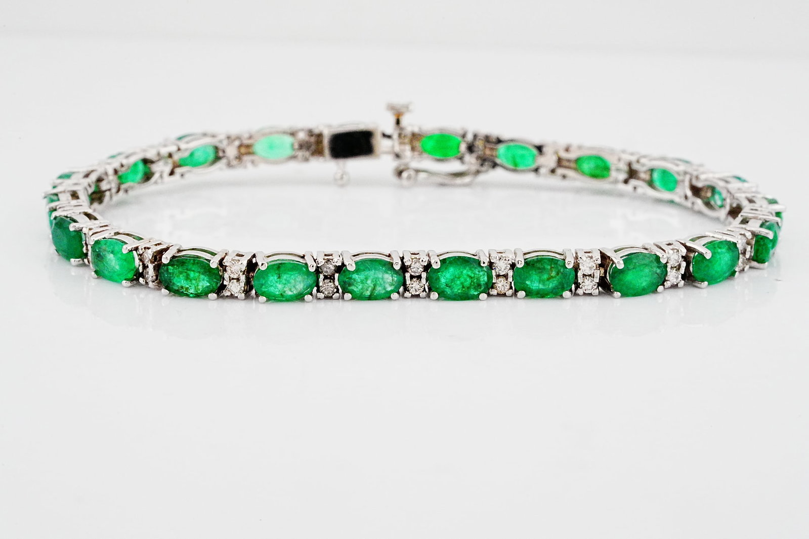 12.00ctw Emerald, 1.00ctw Diamond and 14K 7" Bracelet: 12.00ctw Emerald, 1.00ctw SI1-SI2/G-H Diamond and 14K White Gold 7" Bracelet - THIS ITEM WILL COME WITH A $15,000 INSURANCE VALUATION REPORT. An elegant and vibrant bracelet crafted in polished 14K wh
