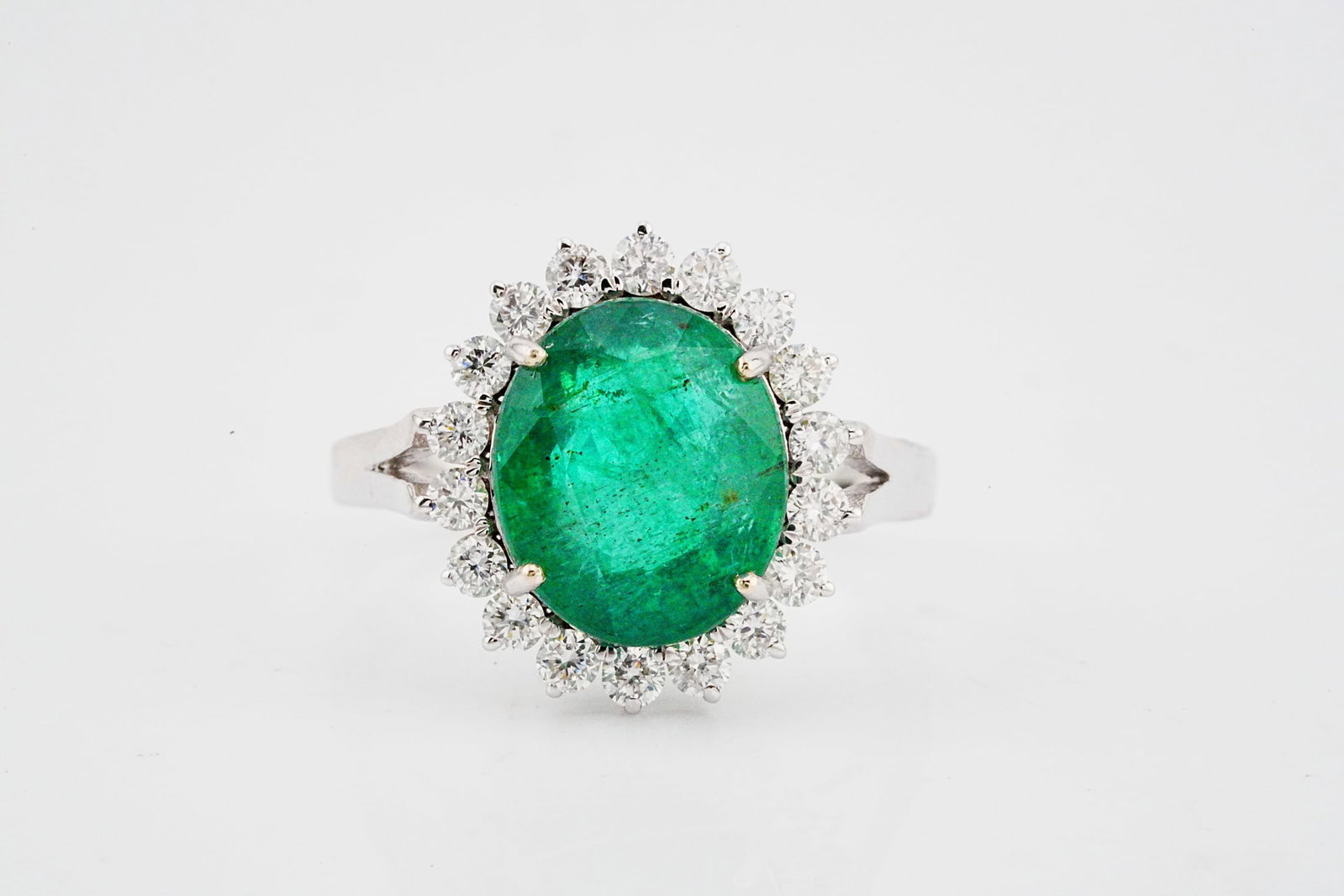 4.40ct Emerald, 0.60ctw Diamond and 18K White Gold Ring: 4.40ct Emerald, 0.60ctw VS1-SI1/G-H Diamond and 18K White Gold Ring - THIS ITEM WILL COME WITH A $11,000 INSURANCE VALUATION REPORT. A striking and elegant statement piece showcasing a vibrant 4.40 ca