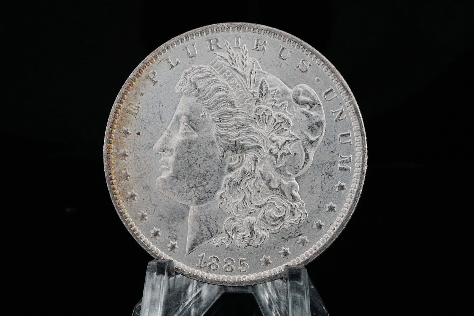1885-O Morgan Silver Dollar W/Toned Rim MS65+: 1885-O Morgan Silver Dollar W/Toned Rim MS65+ (90% Silver) - Truly a magnificent example, this exceptional 1885-O Morgan Silver Dollar presents with outstanding preservation and breathtaking eye appea