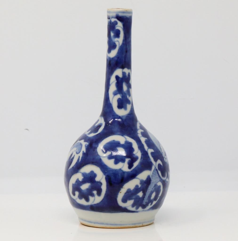 Vietnamese Blue and White Porcelain Vase: Vietnamese Blue and White Porcelain Vase W/Dragon Motif - This porcelain vase is decorated with a scrolling dragon amongst a densely populated background of stylized clouds. Measurements: 7"H x3.25"W.
