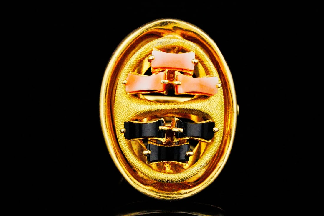 18K Yellow Gold, Coral and Onyx Ring: 18K Yellow Gold, Coral and Onyx Ring - This striking 18K Yellow Gold ring is a bold expression of vintage-inspired design, showcasing a beautifully sculpted oval form that commands attention. At its c
