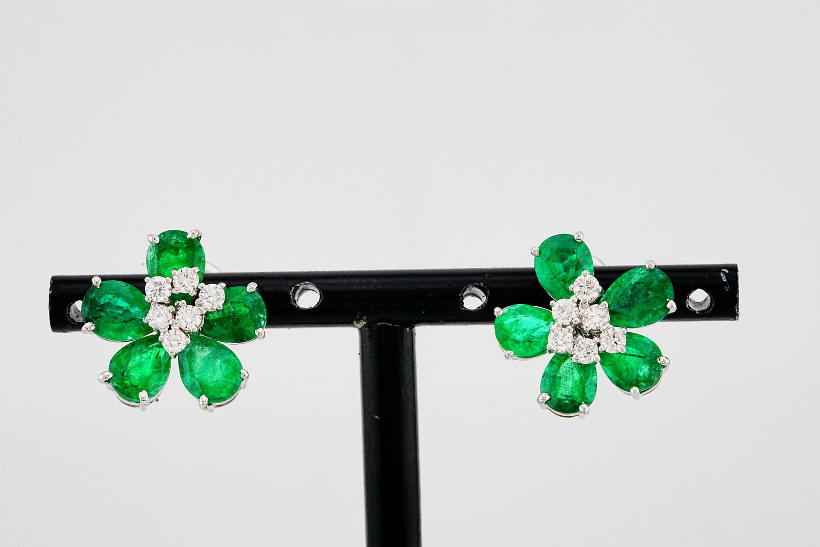 6.40ctw Emerald, 0.50ctw Diamond and 18K Flower Earrings: 6.40ctw Emerald, 0.50ctw Diamond and 18K White Gold 0.60" Flower Stud Earrings - THIS ITEM WILL COME WITH A $13,000 INSURANCE VALUATION REPORT. Elegant floral-inspired stud earrings crafted in 18K whi