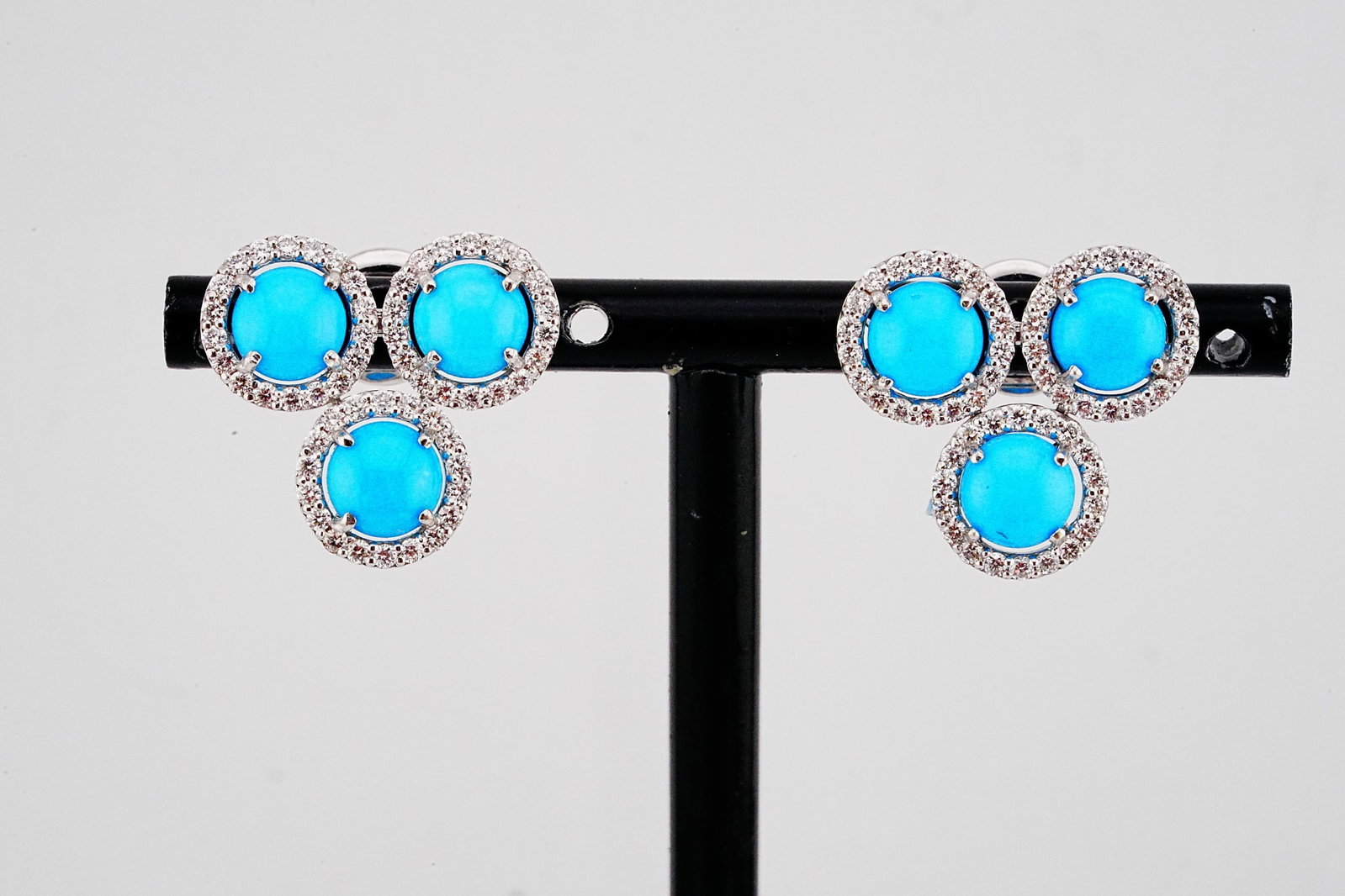 4.55ctw Turquoise, 1.00ctw Diamond and 18K Earrings: 4.55ctw Turquoise, 1.00ctw SI1-SI2/G-H Diamond and 18K White Gold 0.75" Trefoil Stud Earrings - THIS ITEM WILL COME WITH AN $8,000 INSURANCE VALUATION REPORT. Exquisitely crafted in radiant 18K white 