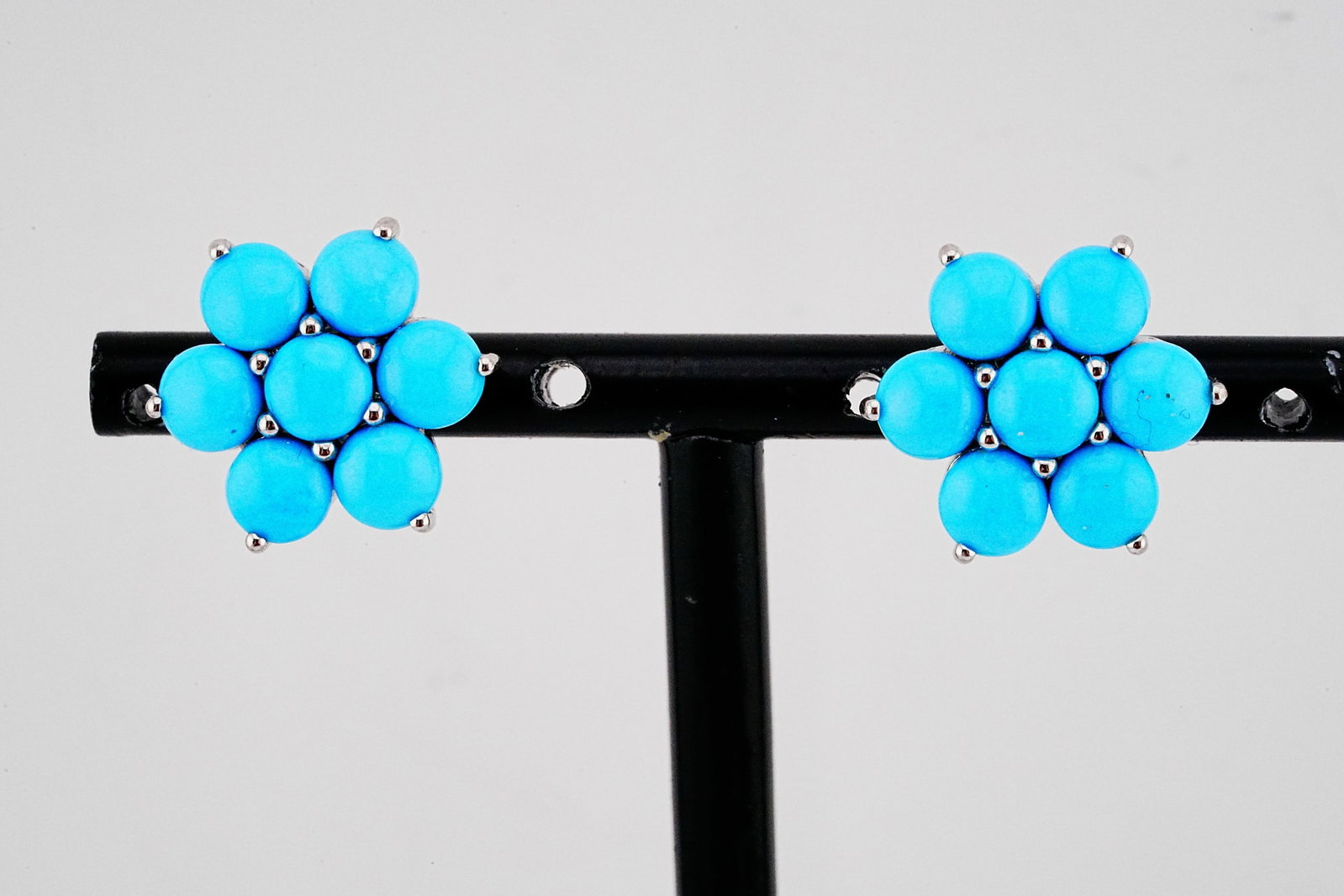 6.60ctw Turquoise and 18K White Gold Flower Earrings: 6.60ctw Turquoise and 18K White Gold 0.65" Flower Stud Earrings - THIS ITEM WILL COME WITH A $5,000 INSURANCE VALUATION REPORT. Elegant and timeless, these finely crafted stud earrings showcase a vibr