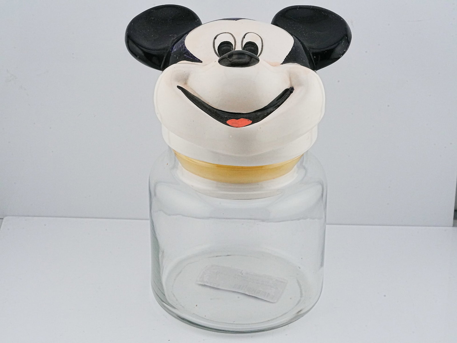Vintage Walt Disney Company Mickey Mouse Cookie Jar: Vintage Walt Disney Company Mickey Mouse Ceramic Head Lidded Glass Cookie Jar - A charming vintage Walt Disney Company lidded jar featuring a classic Mickey Mouse head as the ceramic lid. The expressi