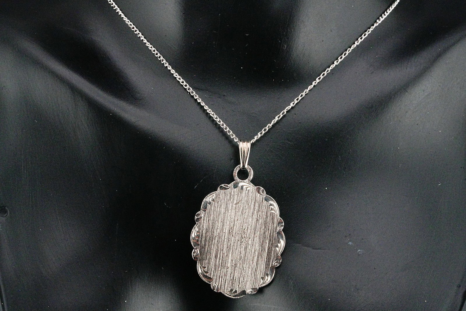 Sterling Silver 18" Oval Pendant Necklace: Sterling Silver 18" Oval Pendant Necklace - This elegant piece features a classic oval pendant crafted in sterling silver with a finely engraved, engine-turned center and a delicately scalloped border