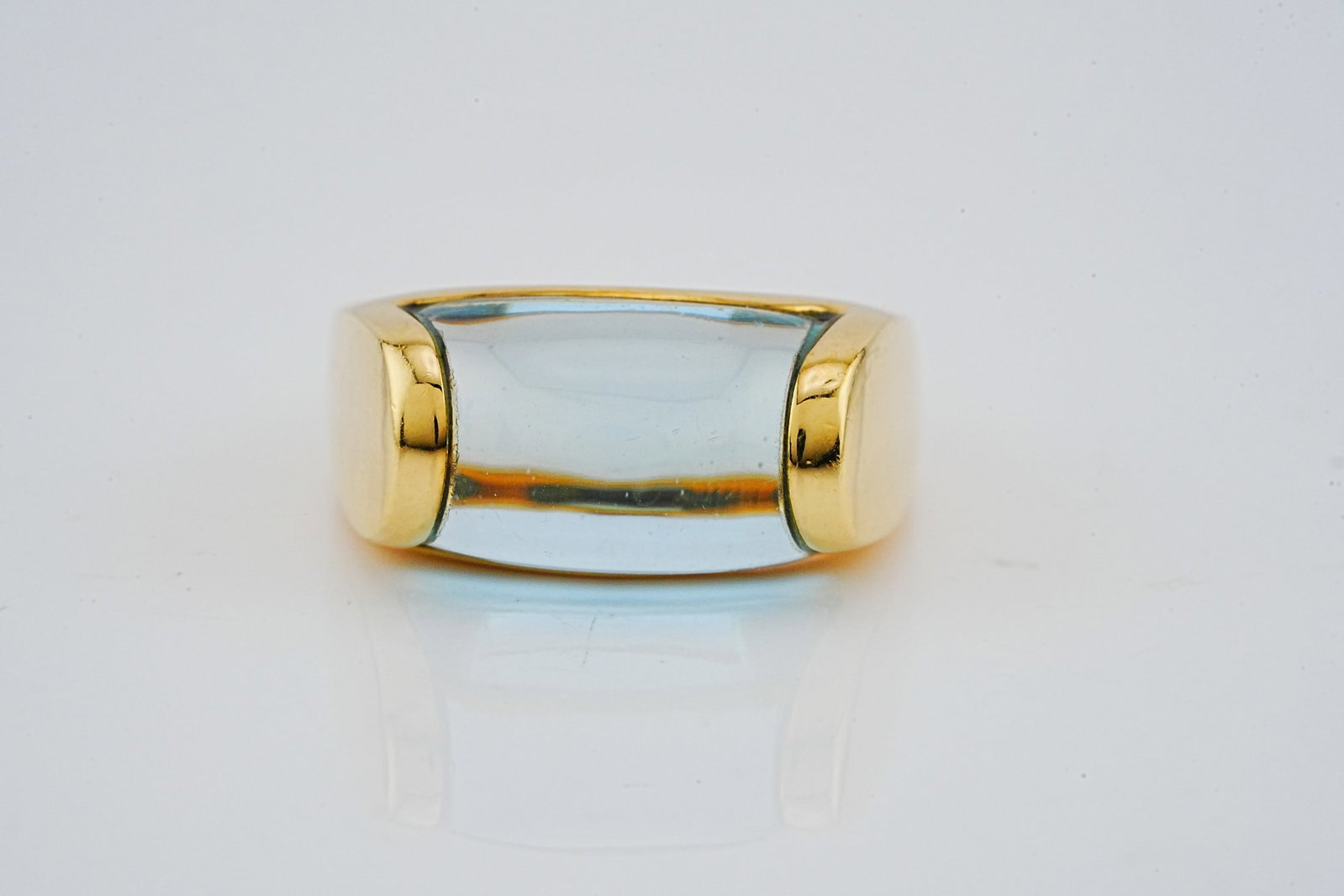Bvlgari Tronchetto 18K Yellow Gold and Blue Topaz Ring: Bvlgari Tronchetto 18K Yellow Gold and Blue Topaz Ring - A bold and iconic Bvlgari Tronchetto ring crafted in luminous 18K yellow gold, featuring a striking blue topaz set flush within the sculptural 