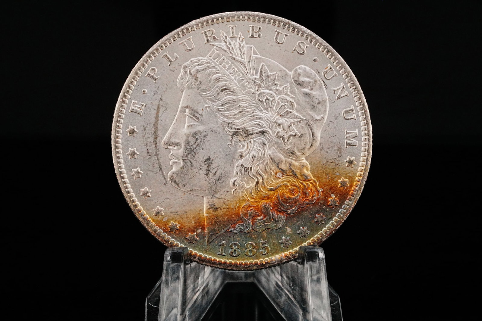 1885-O Morgan Silver Dollar MS65+ W/Rainbow Toning: 1885-O Morgan Silver Dollar MS65+ W/Rainbow Toning (90% Silver) - An absolutely breathtaking New Orleans Mint Morgan Dollar, this 1885-O example boasts exceptional eye appeal with vibrant natural