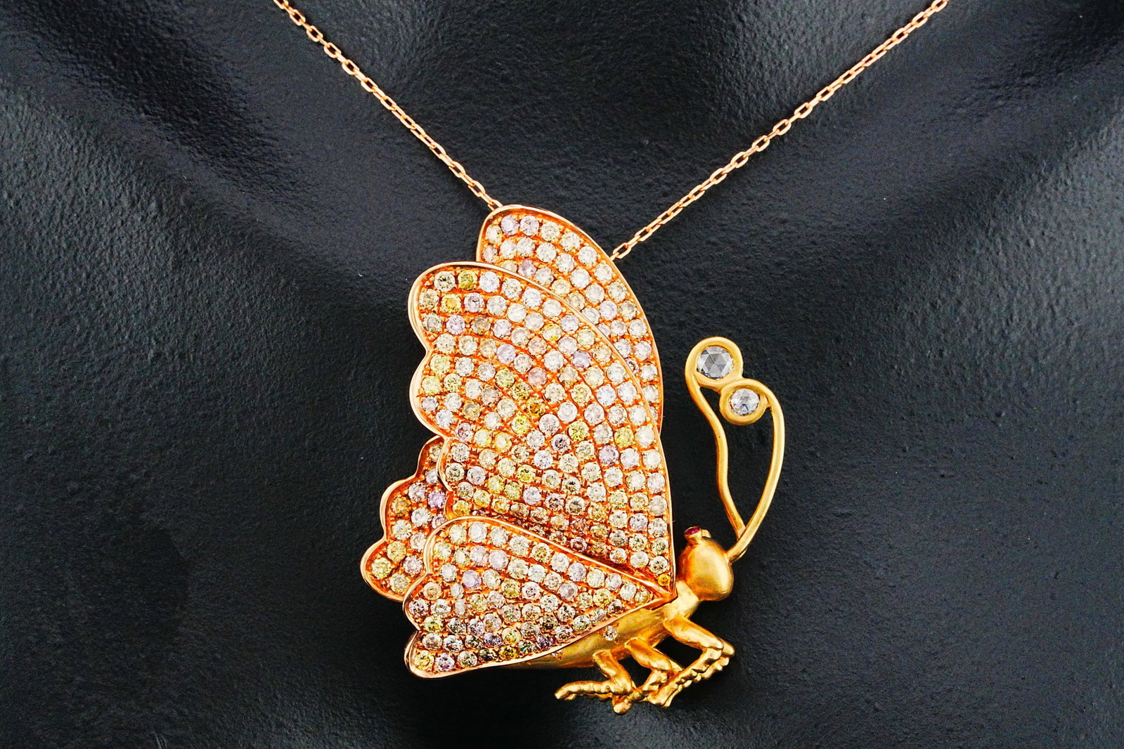 4.90ctw Diamond and 14K 18" Butterfly Necklace: 4.90ctw Multi-Color Diamond and 14K Yellow/Rose Gold 18" Butterfly Pendant Necklace W/Ruby Accents - THIS ITEM WILL COME WITH AN $11,500 INSURANCE VALUATION REPORT. A whimsical yet luxurious statement