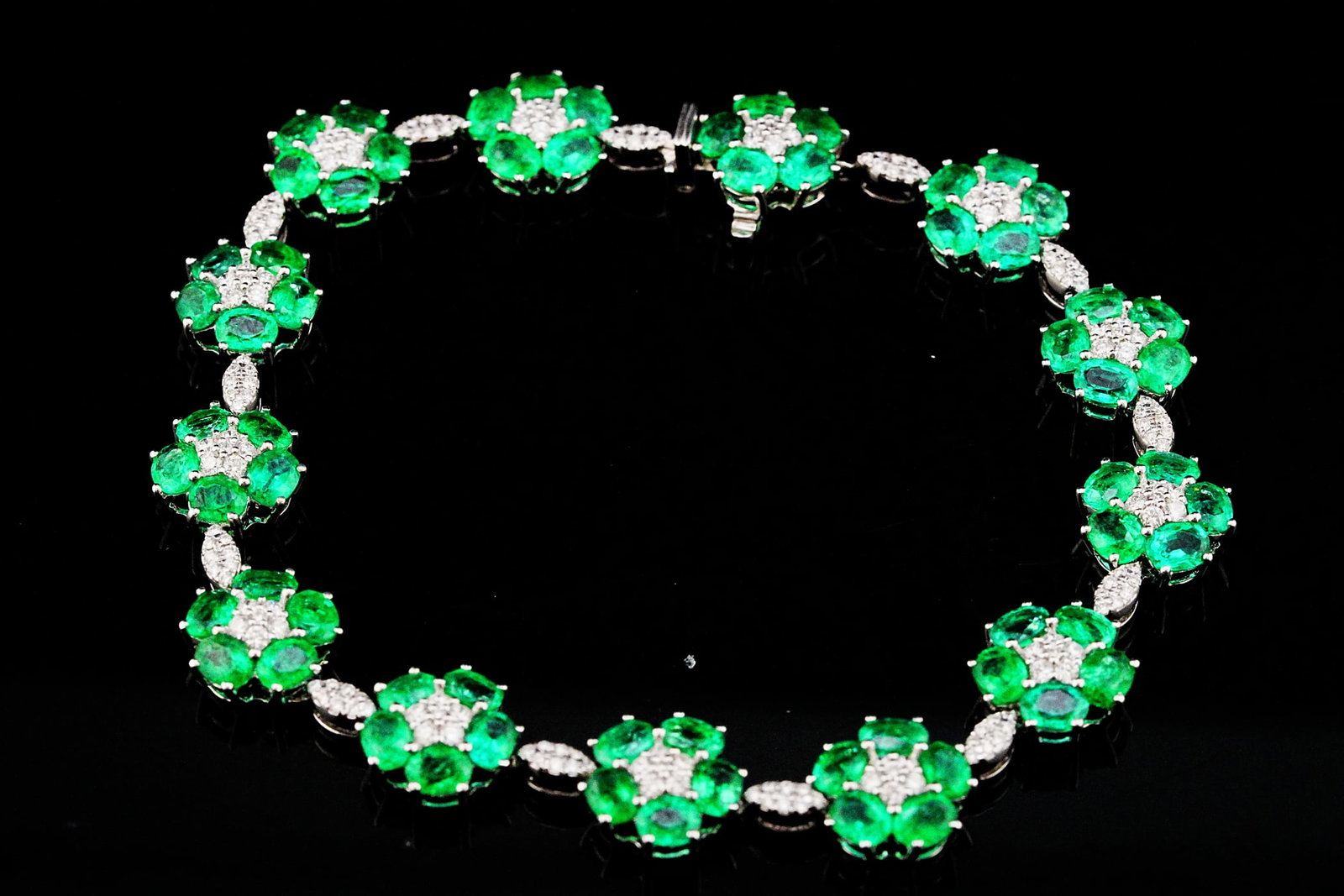 11.15ctw Emerald, 1.25ctw Diamond and 18K 7.25" Bracelet: 11.15ctw Emerald, 1.25ctw SI1-SI2/G-H Diamond and 18K White Gold 7.25" Floral Garland Bracelet - THIS ITEM WILL COME WITH A $22,000 INSURANCE VALUATION REPORT. Delicate botanical beauty meets exceptio