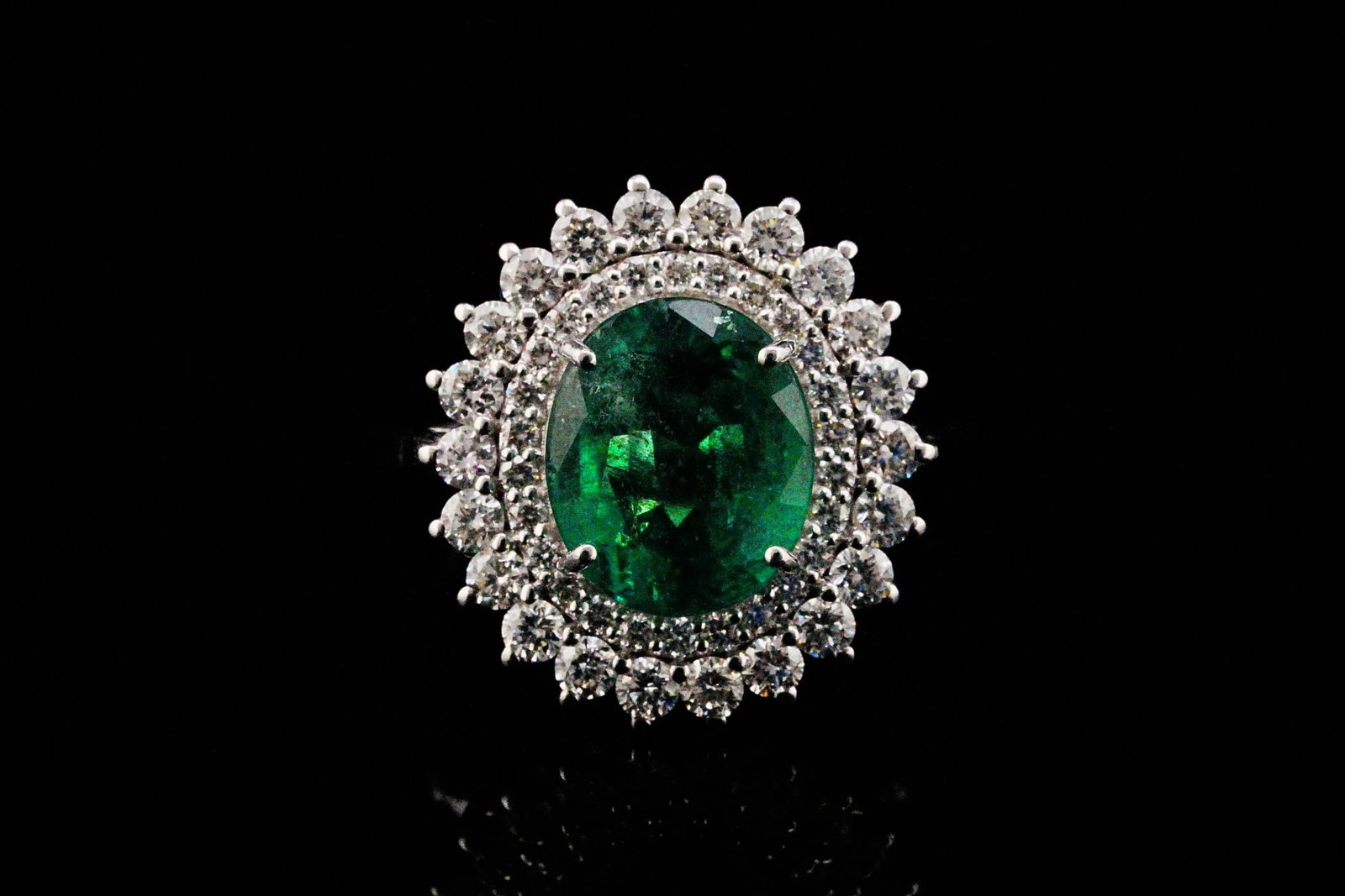 3.70ct Emerald, 1.00ctw Diamond and 18K White Gold Ring: 3.70ct Emerald, 1.00ctw VS1-VS2/G-H Diamond and 18K White Gold Ring - THIS ITEM WILL COME WITH A $10,000 INSURANCE VALUATION REPORT. Showcasing a captivating approximate 3.70 carat oval-cut emerald, t