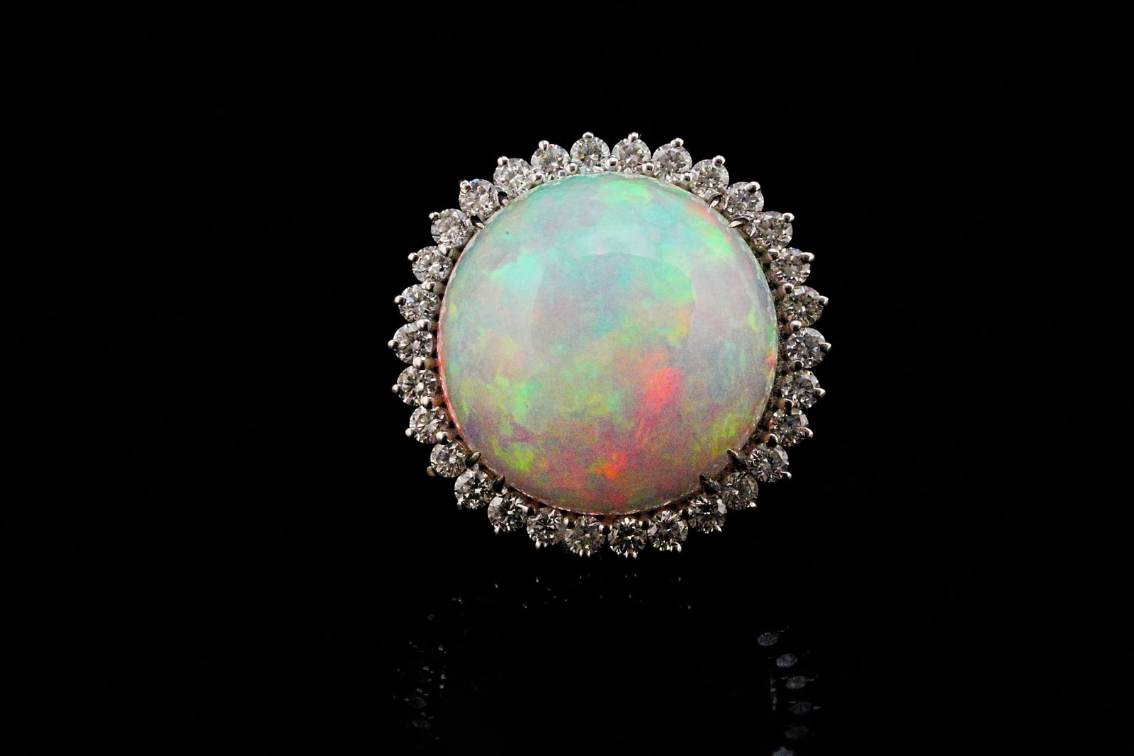 14.90ct Opal, 0.90ctw VS2-SI2/G-H Diamond and 18K Ring: 14.90ct Opal, 0.90ctw VS2-SI2/G-H Diamond and 18K White Gold Ring - THIS ITEM WILL COME WITH A $8,500 INSURANCE VALUATION REPORT. Showcasing approximately 14.90 carats of mesmerizing solid natural opa