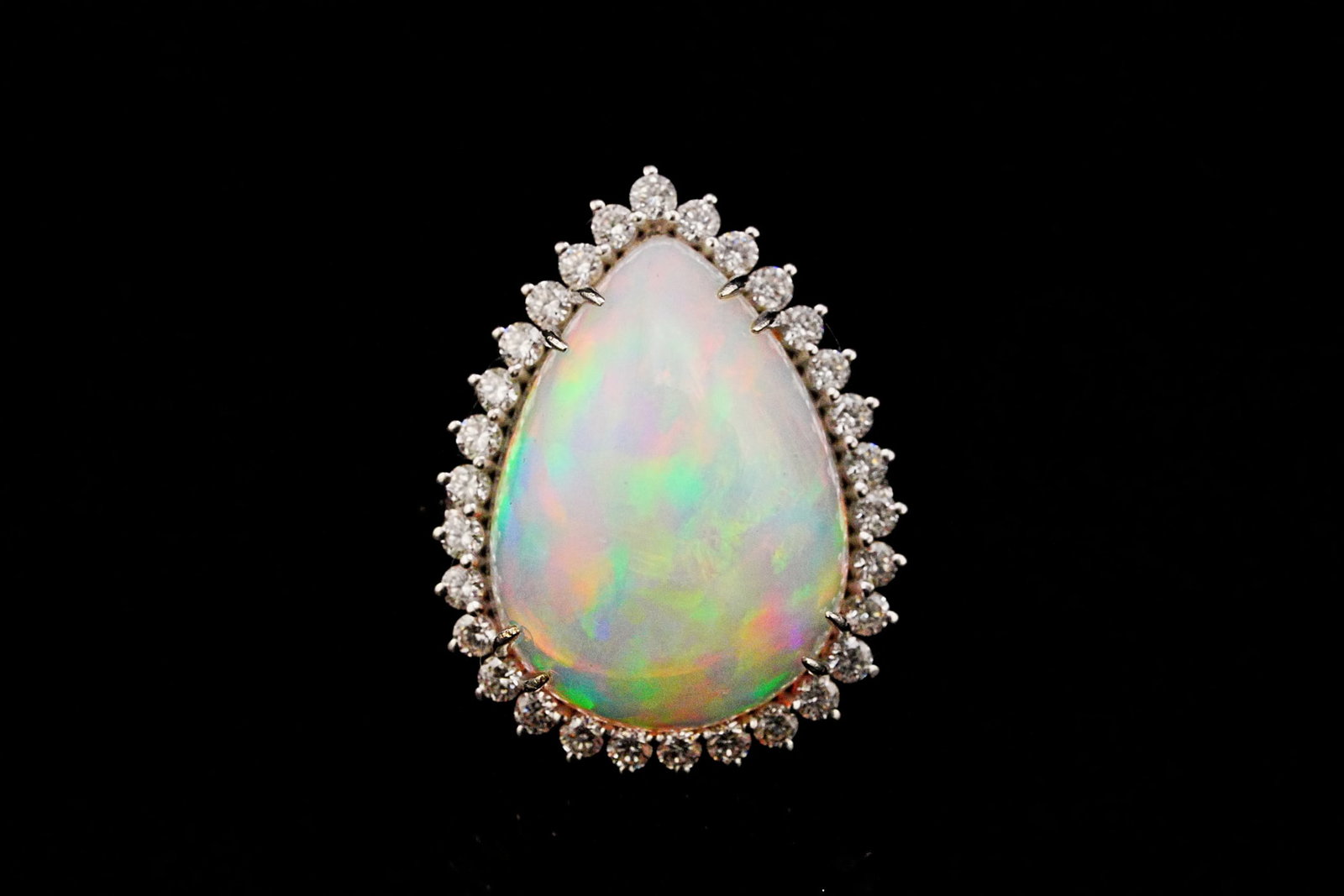 8.90ct Opal, 0.65ctw Diamond and 18K White Gold Ring: 8.90ct Opal, 0.65ctw VS1-VS2/G-H Diamond and 18K White Gold Ring - THIS ITEM WILL COME WITH A $7,750 INSURANCE VALUATION REPORT. Showcasing an approximately 8.90 carat pear-shaped solid natural opal, 