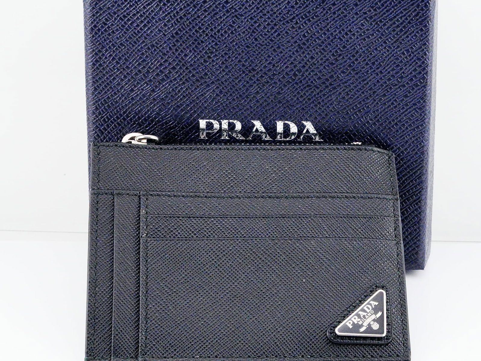 Prada Black Saffiano Leather Zip Card Holder Never Used: Prada Black Saffiano Leather Zip Card Holder Never Used W/Box and Authenticity Card - A refined and highly functional accessory from Prada, this black Saffiano leather zip card holder exemplifies the 