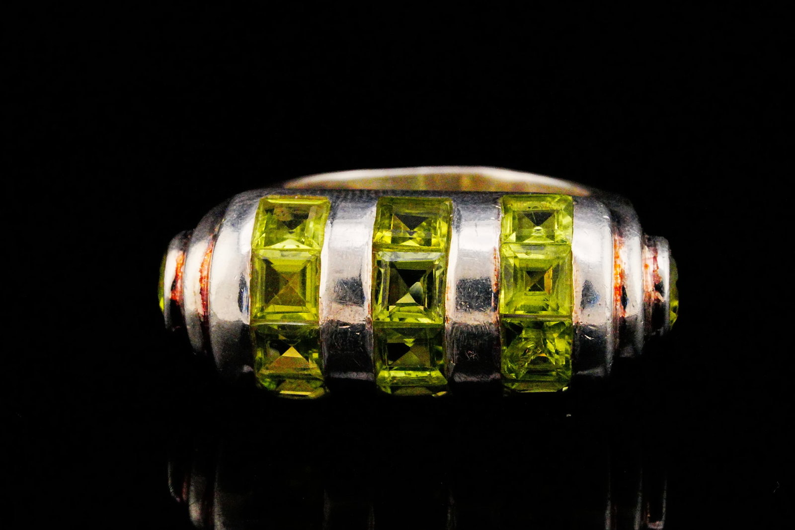 3.60ctw Peridot and Sterling Silver Ring: 3.60ctw Peridot and Sterling Silver Ring - The ring is crafted in sterling silver with channel set square step-cut peridot totaling approximately 3.60 carats. Ring size: 7.75. Weight: 13.4 grams.