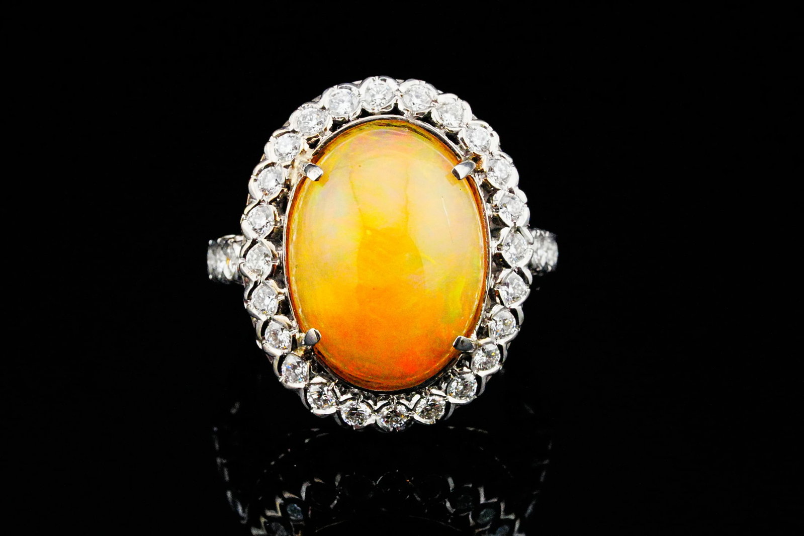 20mm Opal, 1.00ctw Diamond and 18K White Gold Ring: 20mm Opal, 1.00ctw VS1-SI1/G-H Diamond and 18K White Gold Ring - Showcasing a magnificent approximately 20mm oval cabochon opal, this striking 18K white gold ring displays a vibrant play-of-color with