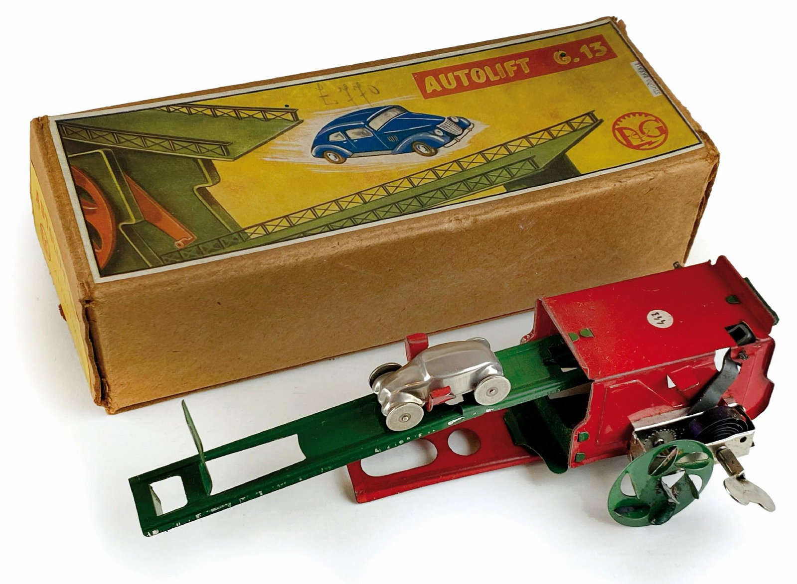 Autolift G. 13 Studio Barale in confezione: Ditta A.G. Autogiochi, Italia, anni '40. In confezione originale cm 21x8x6. Contenente ponte per auto in latta serigrafata con meccanismo a molla con chiavetta integrata ed automobile da lancio. Confe