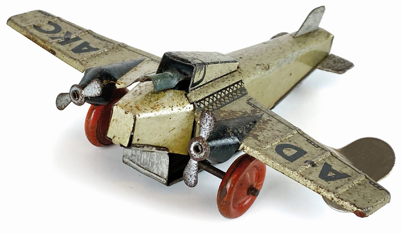 Aeroplano A-D AKC: Ditta non indicata, Germa­nia, anni '30. Latta litogra­fata. Cm 9x12x4. Meccanismo a molla che consente l'avanzamento del velivolo e l'aziona­mento della pietra focaia che produce scintille dal can