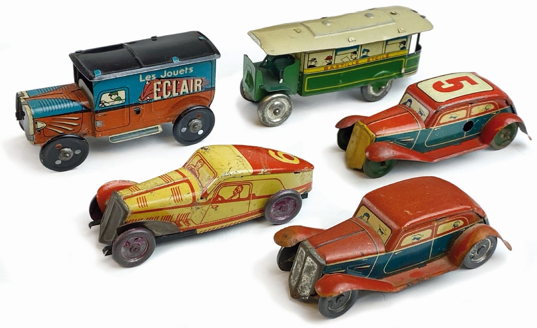 Lotto di cinque modellini francesi Penny Toys: Lotto comporto da cinque modelli in latta litografata Penny Toys, anni 40, composto da furgoncino pubblicitario Le Jouets Eclaire; corriera Bastille Etoiles, auto Berlina, auto Berlina numero 5, ed au