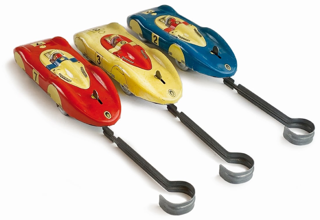 Macchinine Biller-Toy: Lotto composto da tre auto da corsa con movimento a molla, funzionanti. In latta litografata made in U.S. Zone Germany, anni '40, cm 15. Colori assortiti con foglietti di istruzione. Ottimo stato. ENG