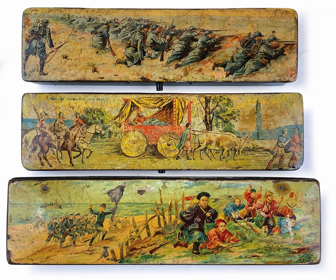 Portapenne Storia e Battaglie: Lotto di 3 astucci in legno litografici, anni '10. Cm 6x22. Sgualciture marginali, buono stato.