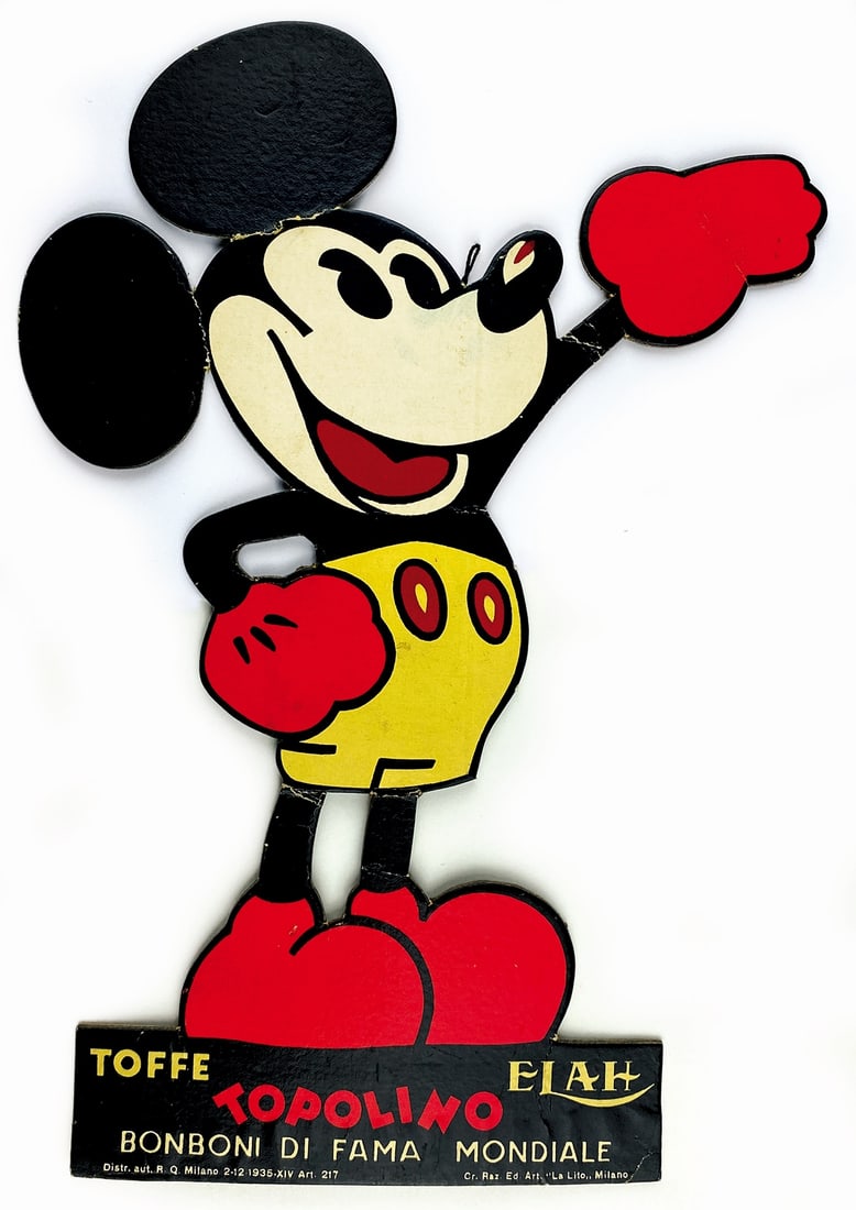 Toffee Elah Topolino: Cartone sagomato pubblicitario, 1935. Altezza cm 29x20. Con segni di piegatura ad un orecchio e alle gambe di Topolino, un'abrasione alla base della sagoma al retro, peraltro buono stato. ENG