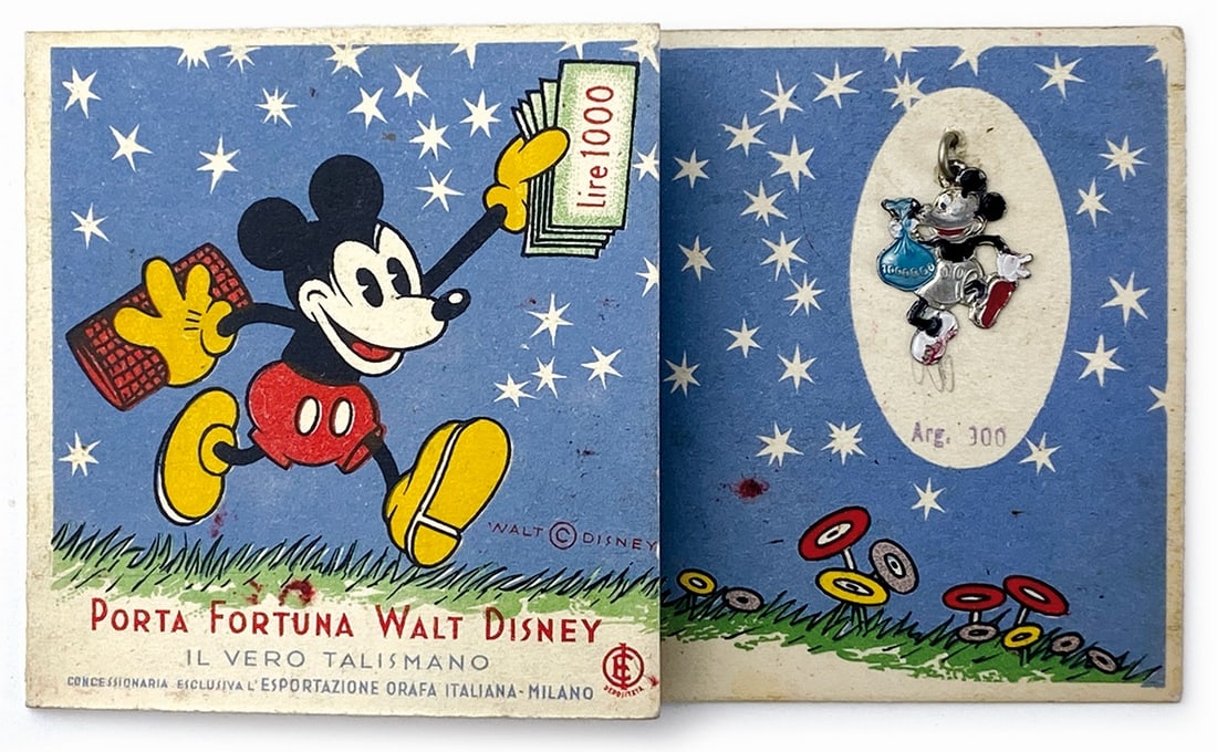 Portafortuna Walt Disney: il Vero Talismano: Cartoncino promozionale per la ditta “Esportazioni orafa” di Milano. Cartoncino 4 ante; cm 7x11,5. Completo del “Talismano di Topolino” in argento smaltato. Raro memorabili che utilizz