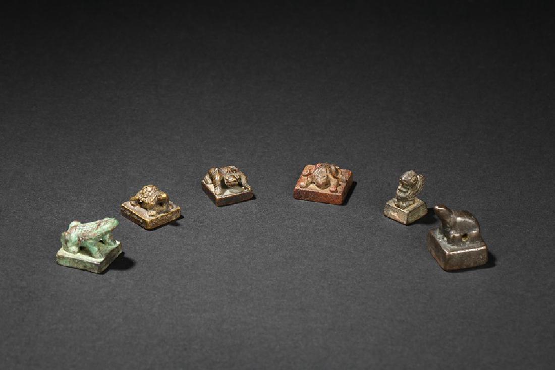 A GROUP OF SIX ANIMAL-FINIAL BRONZE SEALS: All of small section surmounted by various animal-formed handles, the undersides incised with varied zhuanshu inscriptions. Han Dynasty or later. Biggest：Height: 1 in (2.5 cm) Length: 1 in (2.5