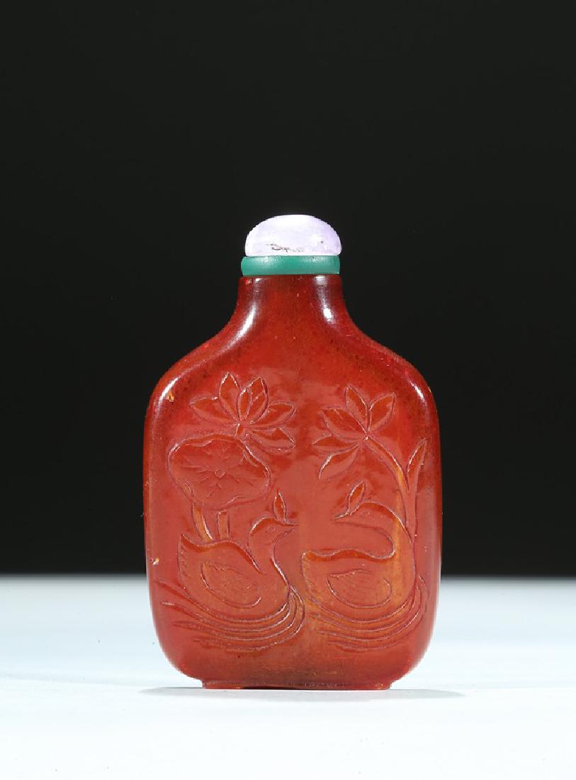 A CHINESE AMBER CARVED 'LOTUS AND DUCKS' SNUFF BOTTLE (1 of 9)