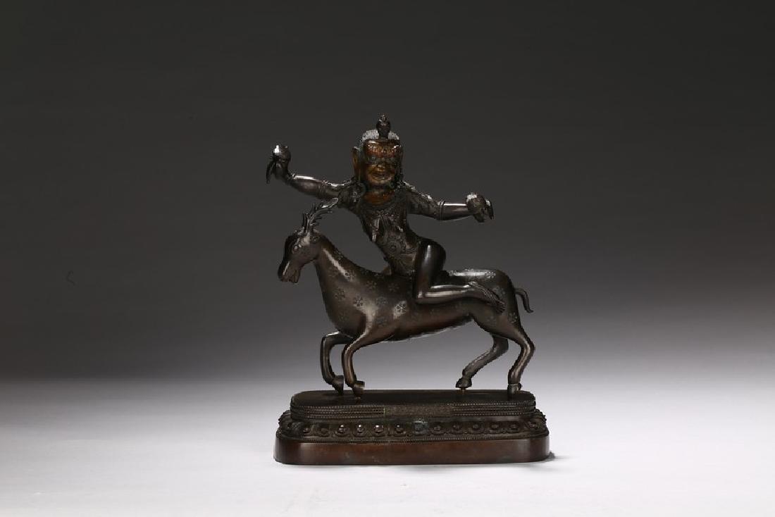 A BRONZE CAST FIGURE OF CHOPEN DRINZANGMA: The deity is shown seated on a deer upon a lotus throne cast with six character reign mark , both hands outstretched holding a ritual object, face with ferocious expression, body adorned with beaded j