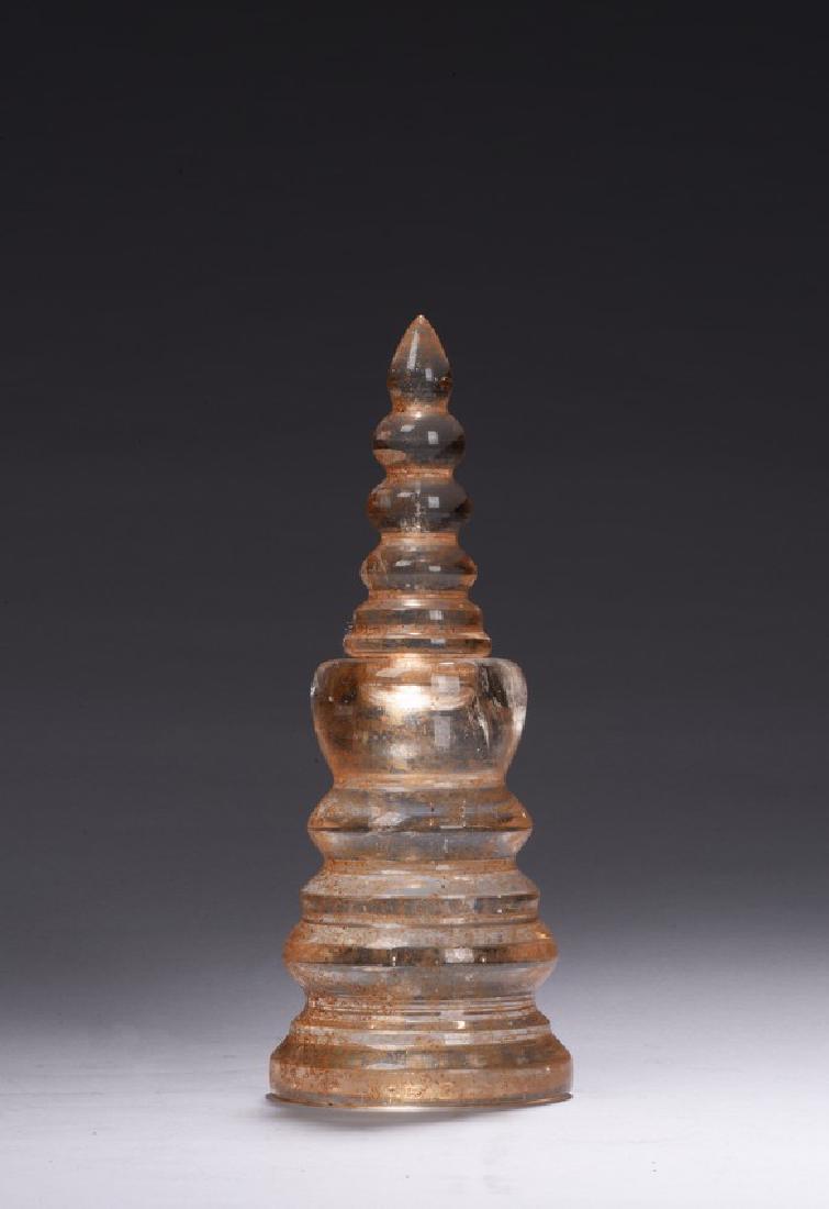A ROCK CRYSTAL CARVED PAGODA: Carved in the form of a buddhist pagoda with sections that can be separated to two parts, the crystal is of clearly transparent with russet markings. Height: 10 in (25.4 cm) Diameter of bottom: 3 7/8 