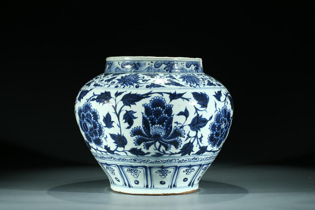 A CHINESE BLUE AND WHITE 'PEONIES' JAR: Ming Dynasty or earlier. Well potted with broad foot rising to a wide rounded shoulder below a short cylindrical neck with slightly thickened mouth rim, the body painted with a broad band of scrolling