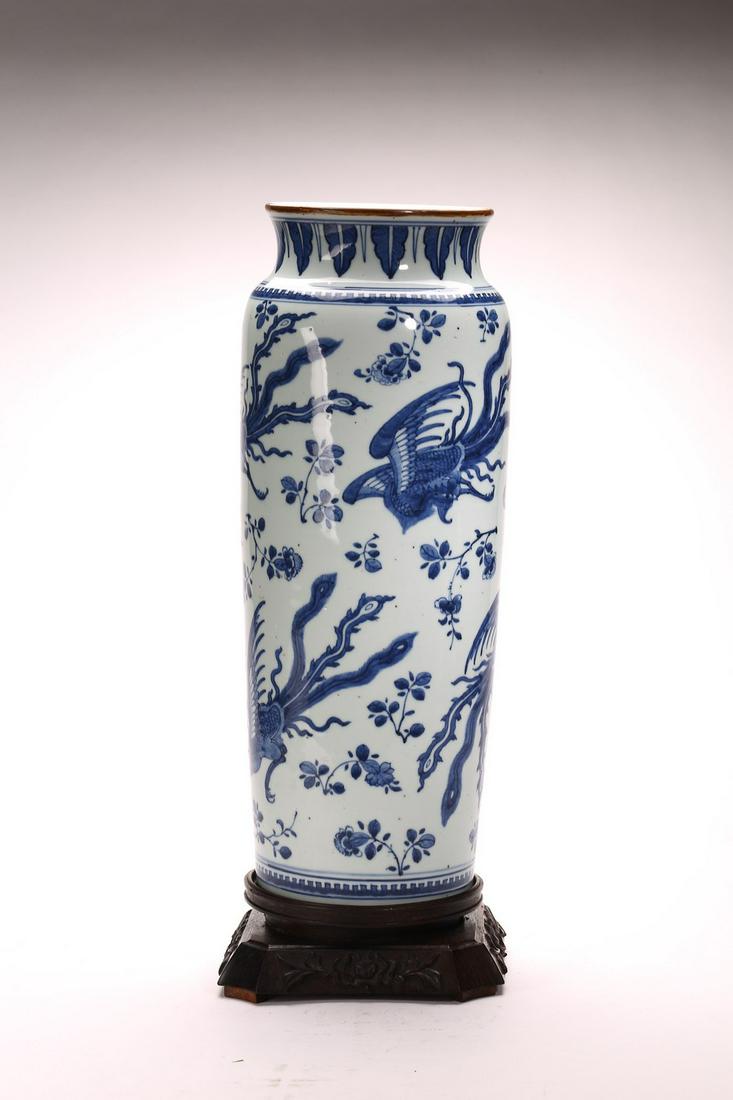 A CHINESE BLUE AND WHITE 'PHOENIX' CYLINDRICAL VASE: Ming Dynasty Chongzhen period. Of cylindrical form, the body decorated with phoenixes in flight amidst various stems of flowers, the neck painted with a band of downward leaves, base left unglazed. He