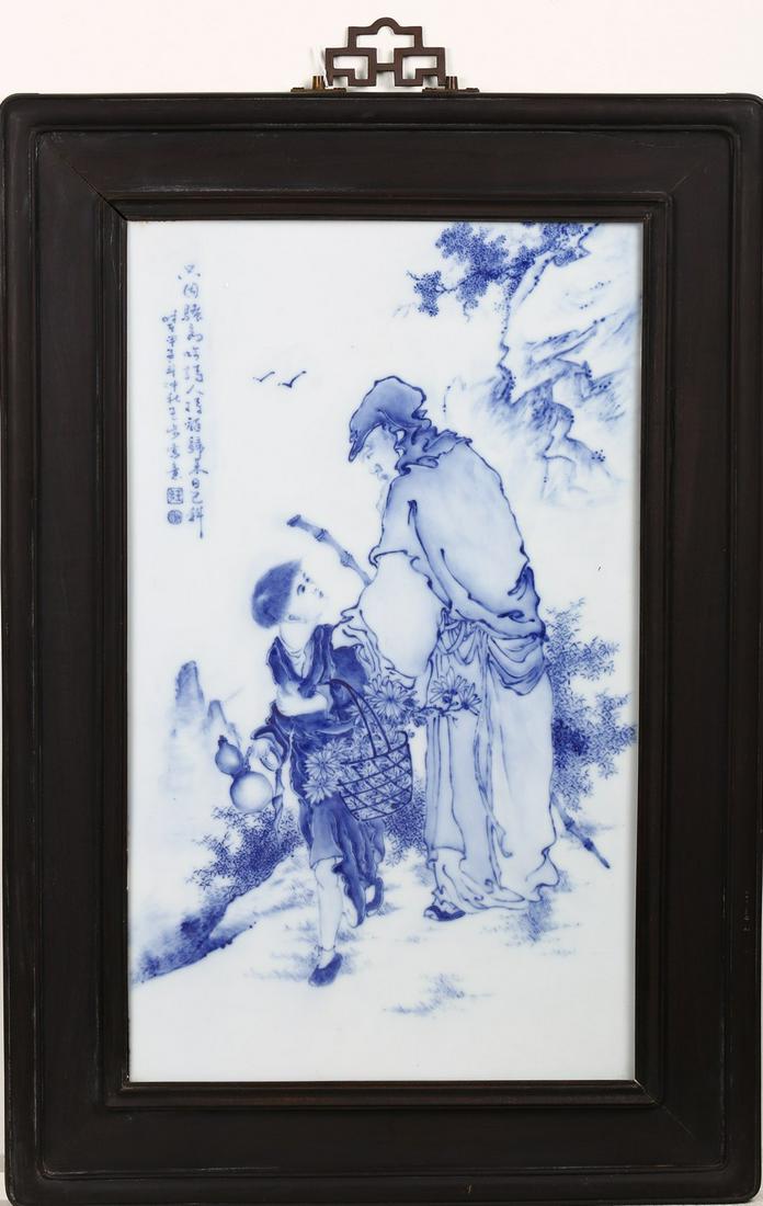 A BLUE AND WHITE 'FIGURES' PORCELAIN PANEL: Of rectangular form, finely painted with a boy holding a double guard on one hand and a basket with flowers on the other hand talking with an elder holding a stick, set in a mountain cliff landscape, 