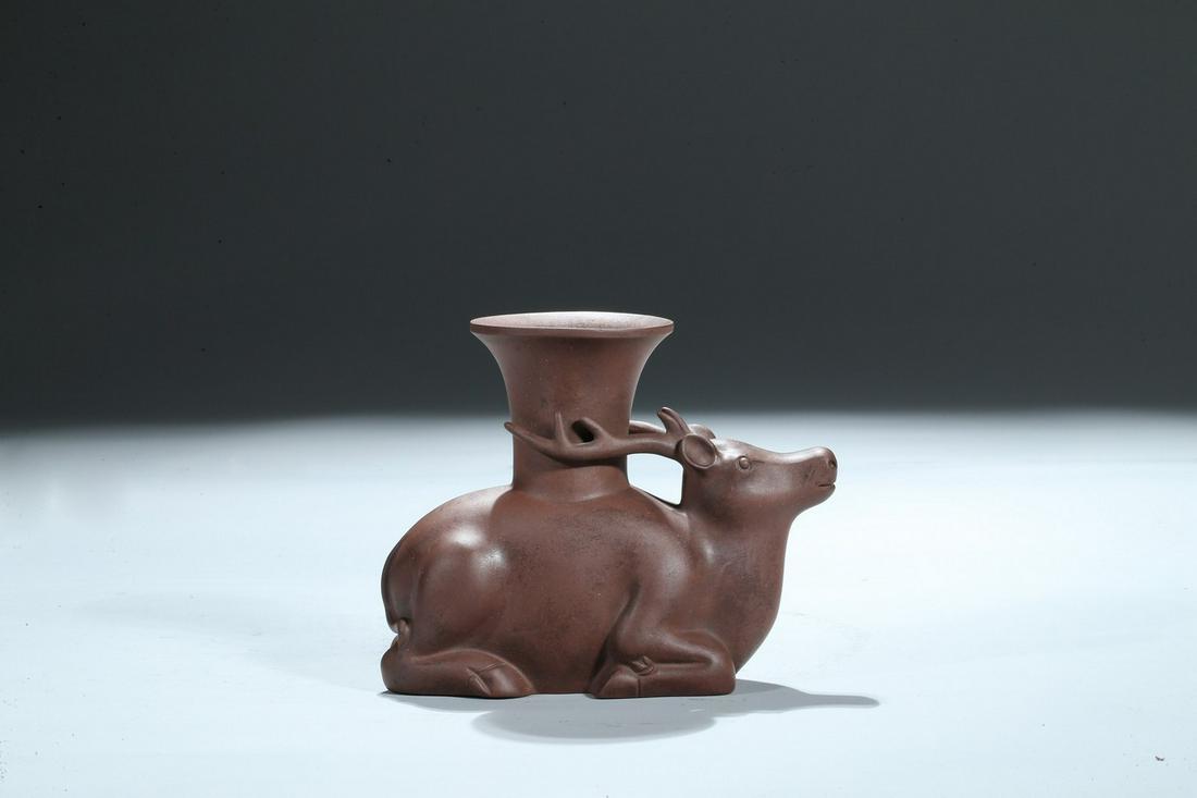 A YIXING ZISHA MODEL OF RECUMBENT 'DEER': Modelled as a recumbent deer, seated on four feet bent to its belly, with head facing forwards, detailed with bulging eyes and big antlers, with one impressed seal of 'Chen ming yuan'. Qing Dynasty pe