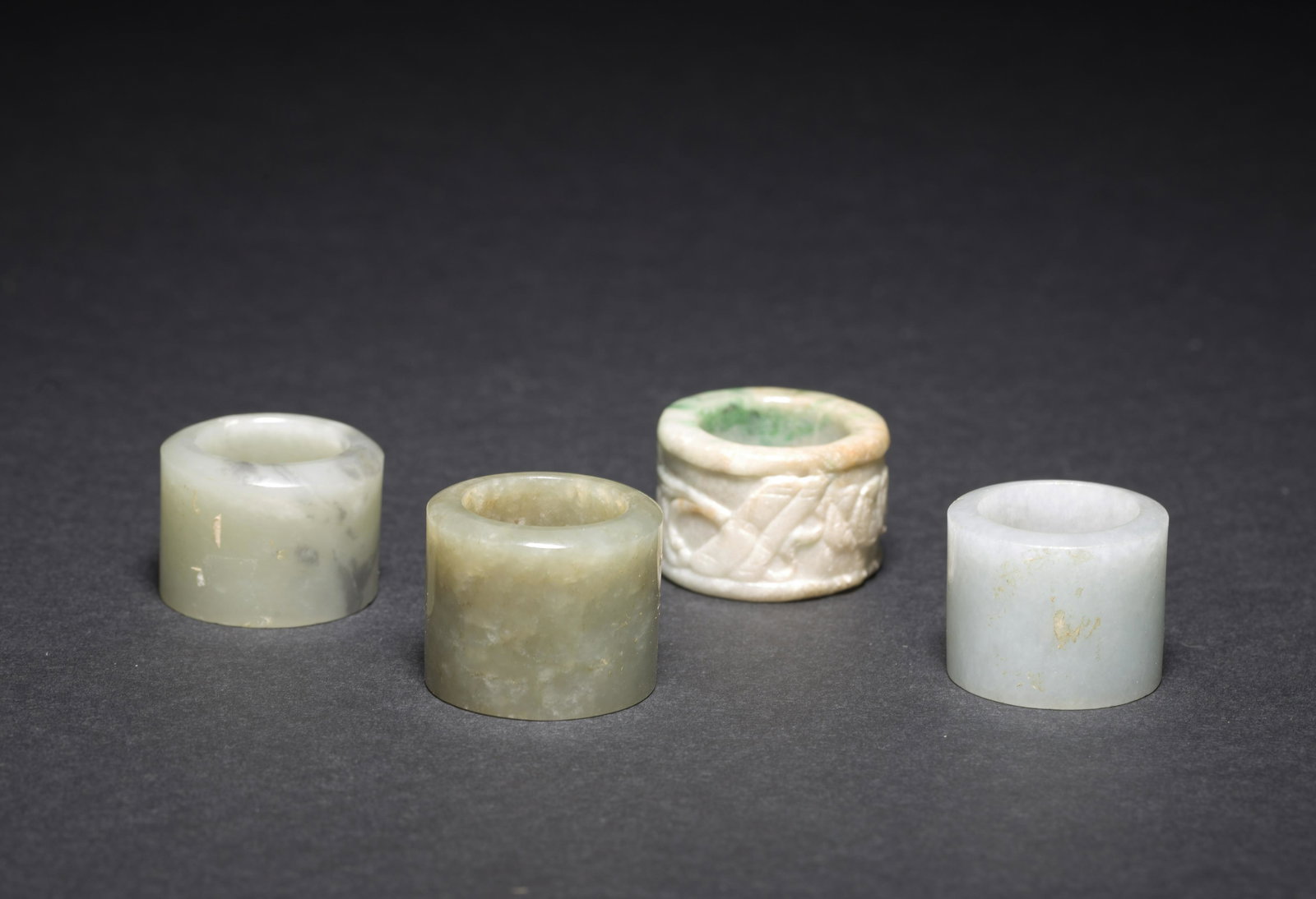 FOUR JADE AND JADEITE ARCHER'S RINGS (1 of 11)