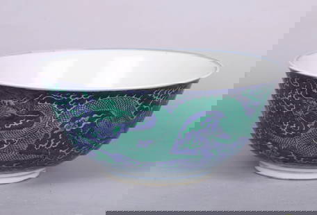AN UNUSUALLY LARGE CHINESE GREEN ENAMEL 'DRAGONS' BOWL: The exterior with two ferocious dragons in pursuit of flaming pearl amidst clouds and flame above crashing waves, the interior painted with a single dragon in a central medallion, the base inscribed w