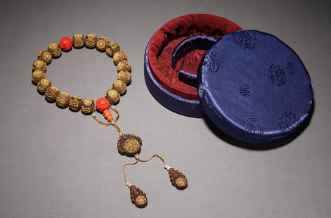 A CHINESE GOLD-BEAD INLAID ALOESWOOD ROSARY BRACELET: Composed of twenty well-polished rounded agarwood beads, each finely inlaid with tiny gold beads with stylized Shou character and roundels, one of them joined by a decorated strand composed of a agarw