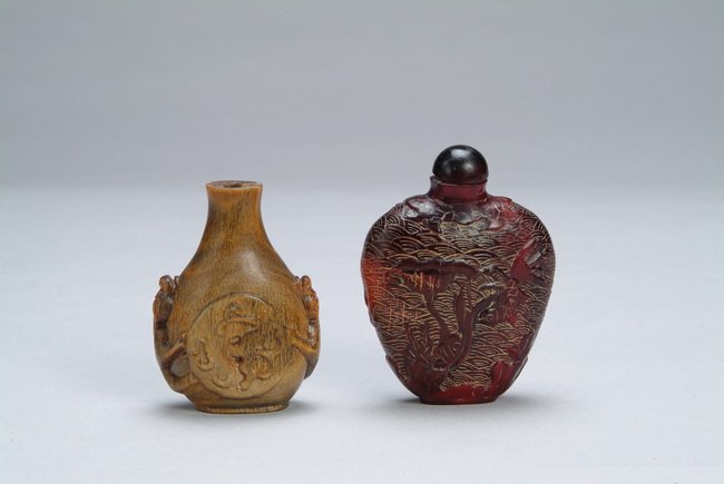 Two (2) Chinese horn carved snuff bottles: One snuff bottle depicts animals, and other snuff bottle depicts trees and scenery; one cap missing. H: 2 3/4 in (7 cm ), H: 3 1/8 in (8 cm )