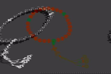 A Chinese Puti Bead Rosary Necklace: 清 菩提子綠鬆石手串 Comprising thirty-six well-matched, lustrous deep red puti beads, interspersed with gilt metal spacers, accented by four turqu